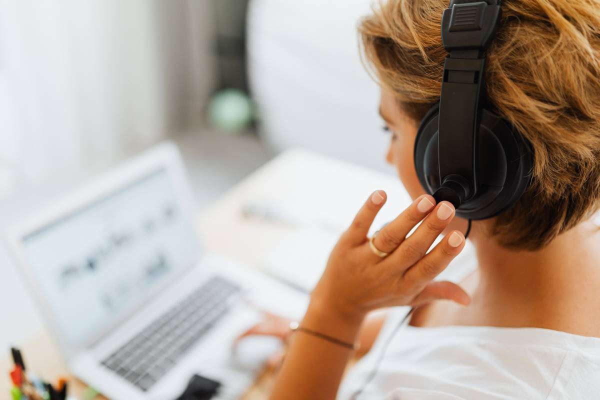 Woman working on laptop with headphones on