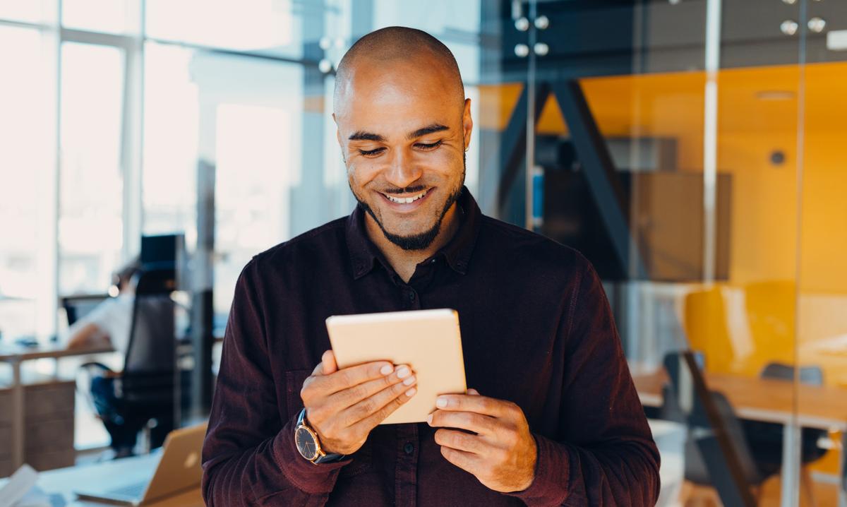 Man smiling and using tablet