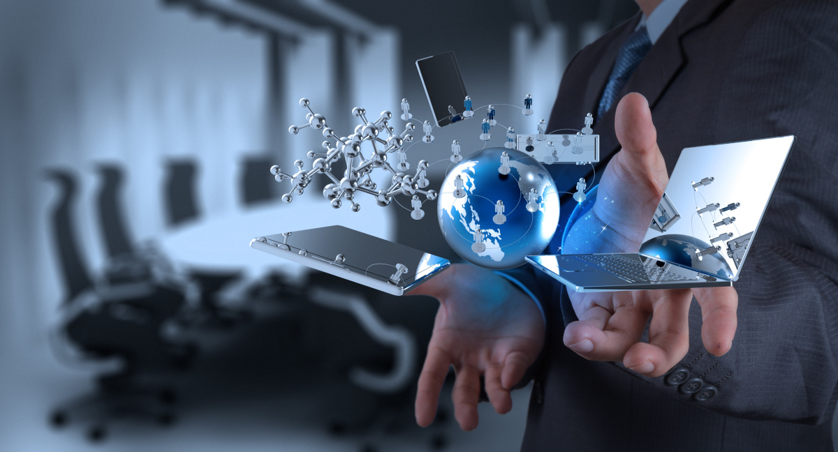 Digital representations of a laptop, two phones, earth, and people icons in front a man's hands