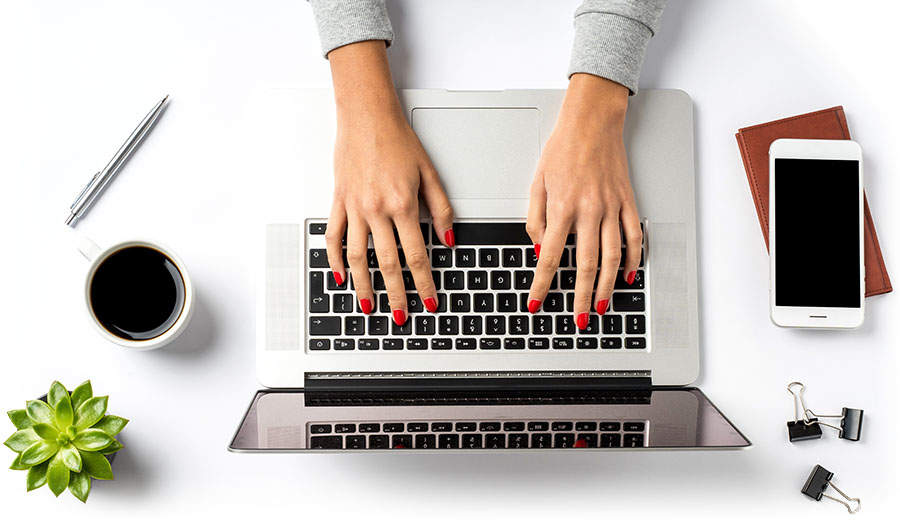 Closeup of woman's hands using laptop computer.