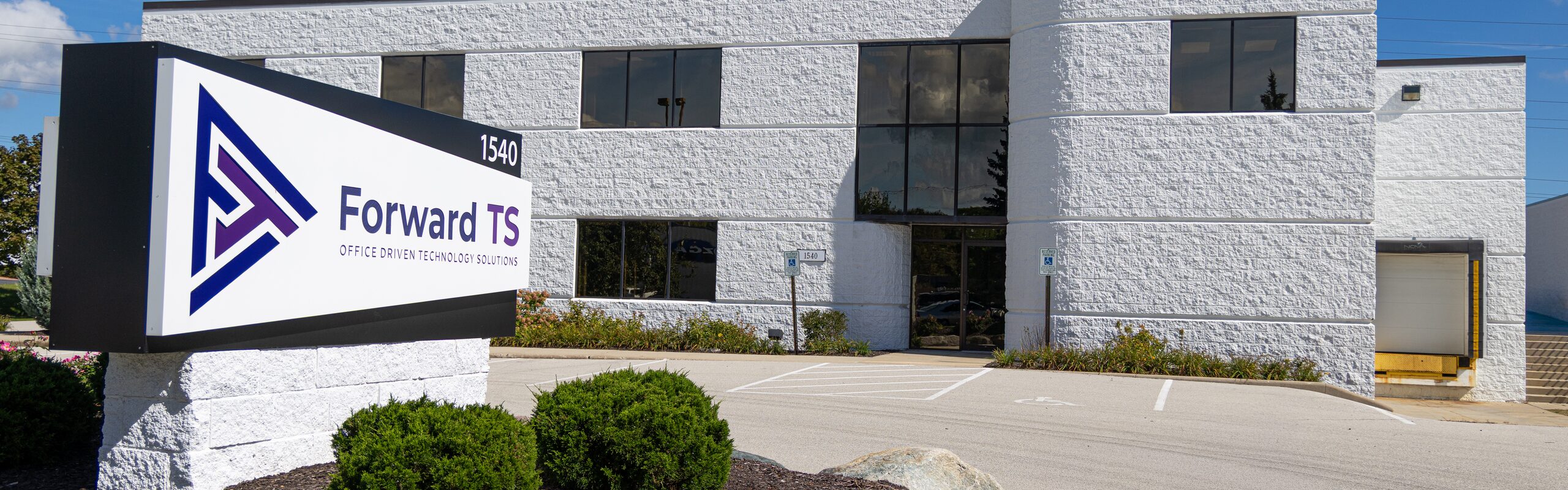 The Forward TS office building and lot on a clear day, with the company monument sign in front in Milwaukee, Wisconsin.